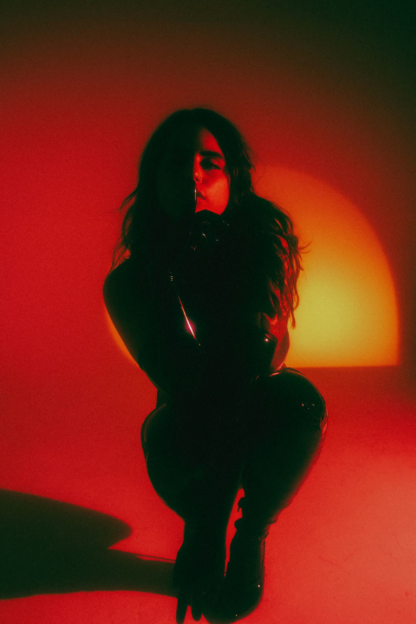 Editorial portrait of a woman posed in deep red studio light